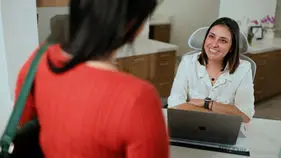 Patient checking in with a team member at the front desk
