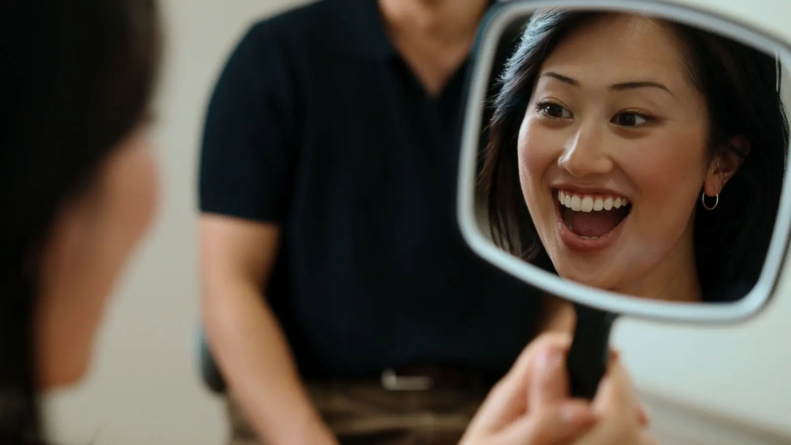 Patient laughing with a hand mirror