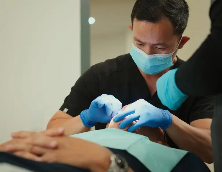 Dr. Nam Bui delivering All-on-4 dental implant new smile at Glo Dental Studio